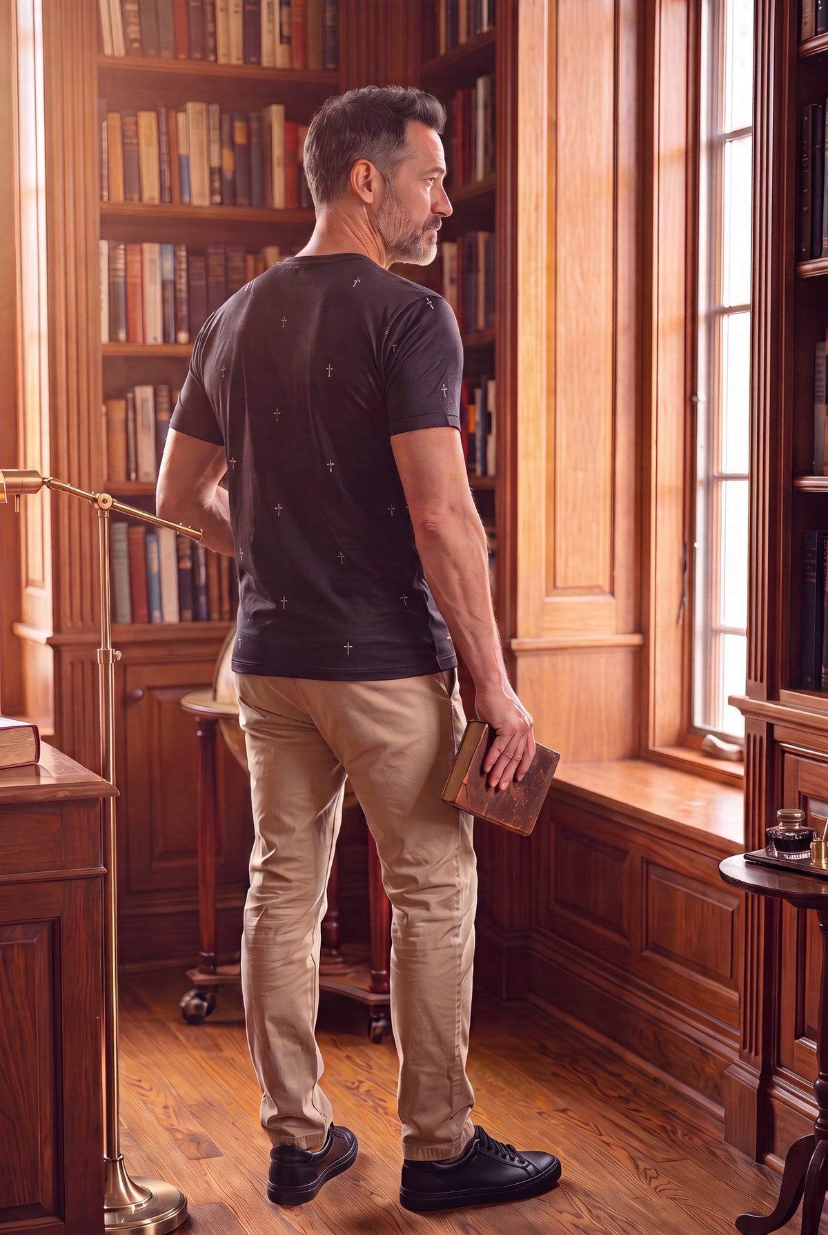 Man wearing Fox and Form -The Cross -hand illustrated pattern classic fit ring spun tee shirt in black standing indoors by a window-Fox and Form Men's Signature Collection. 