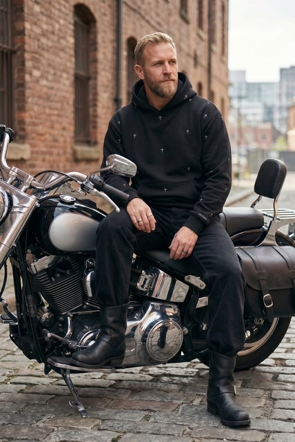 Man sitting on a motorcycle in an urban setting wearing The Cross-max weight sweatshirt in black-hand-illustrated cross pattern design-Fox and Form. Fox and form Mn's Signature Collection. 