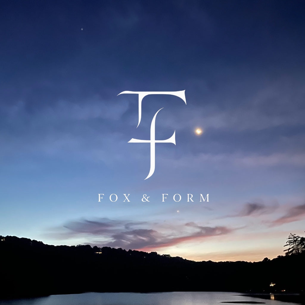 Fox and Form gift card featuring the brand monogram logo over a serene early morning lakeside sky at twilight
