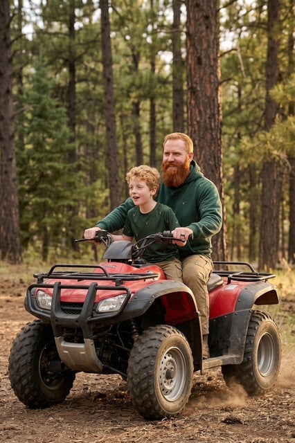 Father and young son riding an ATV together through a pine forest wearing matching Fox and Form The Stag forest green max weight hooded sweatshirt with hand-etched illustrated stag pattern design